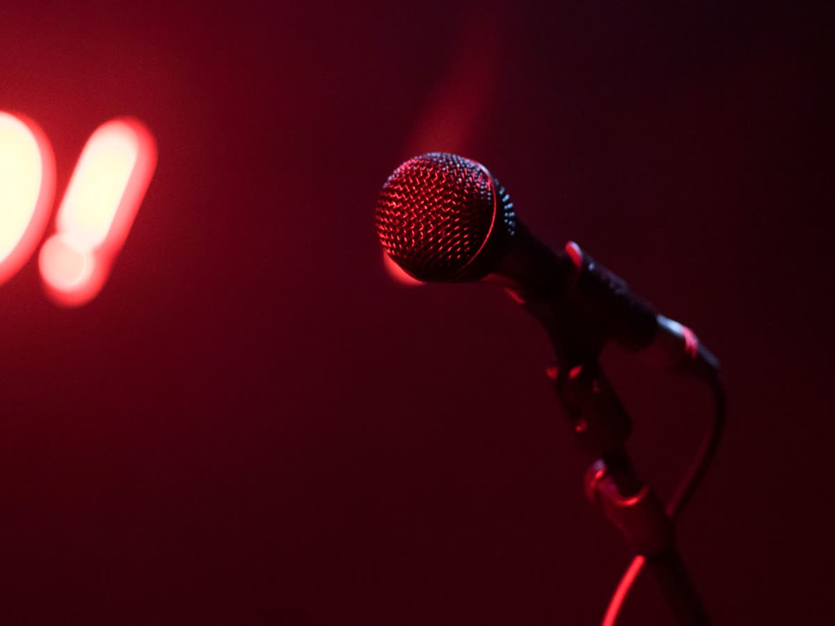 Microphone on a comedy club stage under a red spotlight