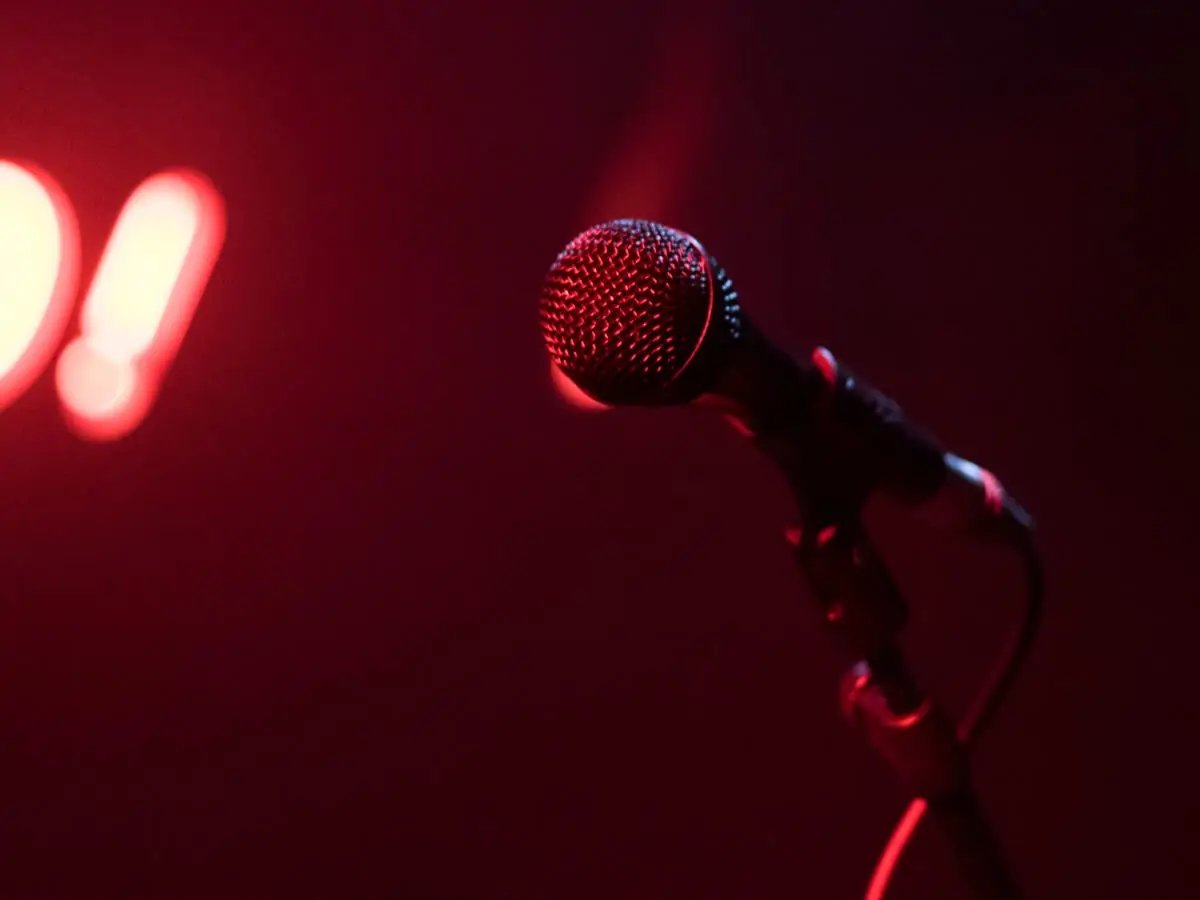 Microphone on a comedy club stage under a red spotlight